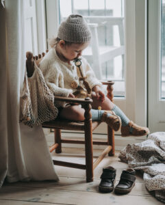 kids photography, kids photography ideas at home, boy wearing sandals by petit nord, sitting in a chair