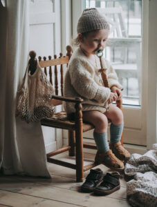 kids photography, kids photography ideas at home, boy wearing sandals by petit nord, sitting in a chair