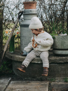 kids photography, kids photography ideas at home, boy in petit nord shoes next to flowers