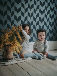 my boys wearing gobabygo socks sitting next to flowers